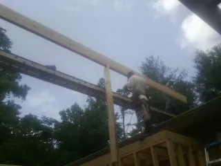 Carpenter setting a ridge beam over a new addition frame — Ice Dam Removal by Roofing Brothers in Carey
