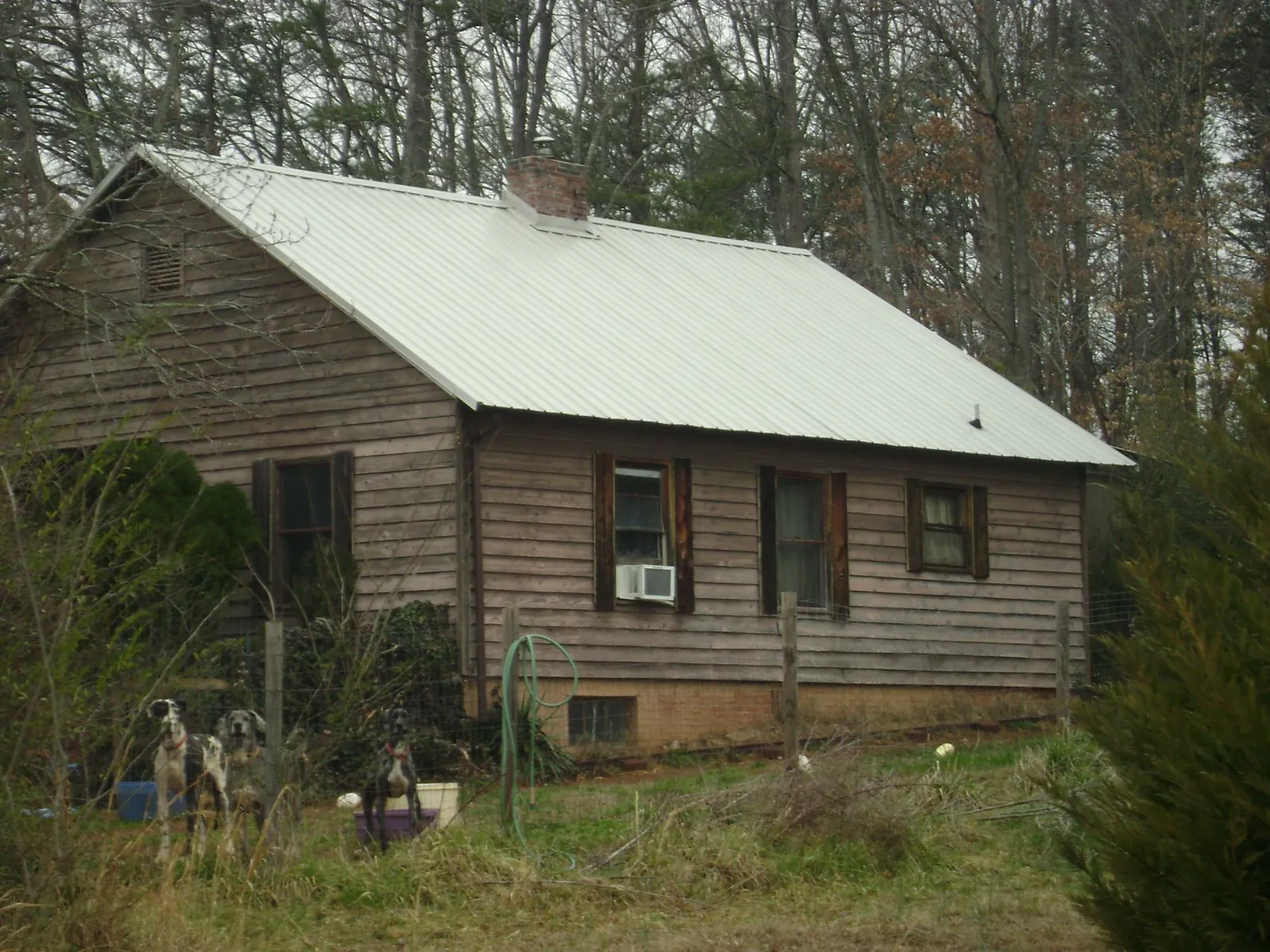 White metal roof on an old wood sided farmhouse, from a Metal Roof Installation job in Carey
